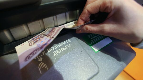 Женщина получает наличные деньги в банкомате 