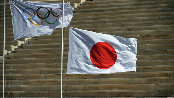 Флаг МОК и флаг Японии во время церемонии передачи олимпийского огня в Афинах 