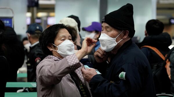 Мужчина и женщина ожидают начала регистрации в международном аэропорту Инчхон, Южная Корея