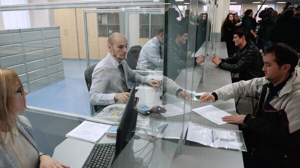 Иностранные граждане разговаривают с сотрудниками центра, получая трудовой патент в Едином миграционном центре Московской области