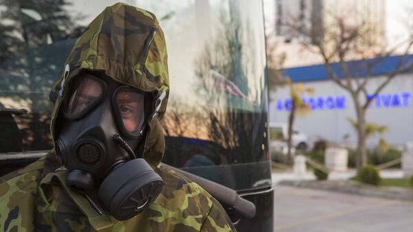 Сотрудник службы безопасности возле автобуса на территории аэропорта Тиват в Черногории