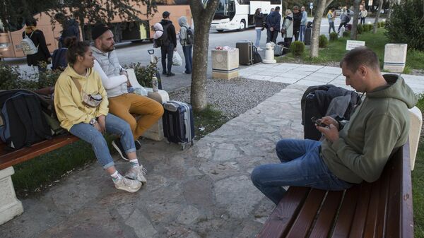 Российские туристы ожидают автобус на территории аэропорта Тиват в Черногории