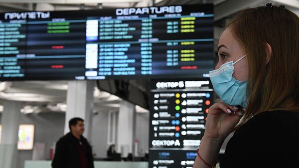 Девушка в медицинской маске в аэропорту Толмачево в Новосибирске