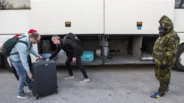 Российские туристы укладывают багаж в автобус на территории аэропорта Тиват в Черногории
