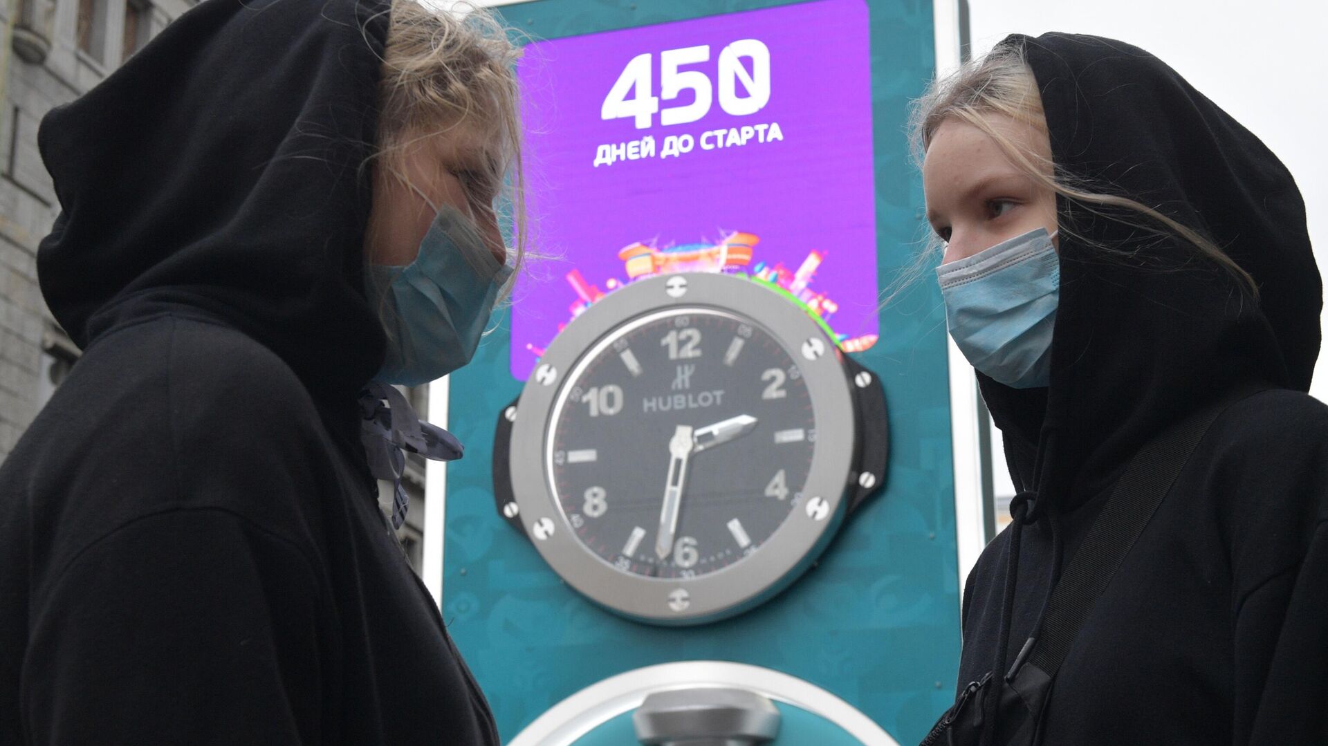Девушки в медицинских масках рядом с часами обратного отсчета времени до старта чемпионата Европы по футболу - РИА Новости, 1920, 17.09.2020