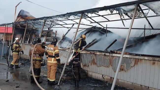 Сотрудники МЧС во время ликвидации пожара на рынке Атлант в Аксайском районе Ростовской области. 20 марта 2020