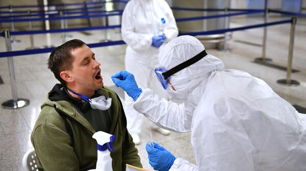 Медицинский работник проверяет состояние пассажира в аэропорту Внуково