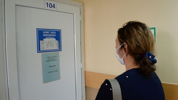 Женщина перед кабинетом поликлиники №1 Владивостока, где проводится сдача анализа на коронавирус