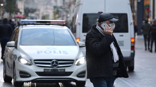 Мужчина в медицинской маске на одной из улиц Стамбула