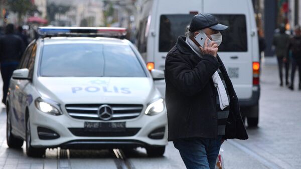 Мужчина в медицинской маске на одной из улиц Стамбула