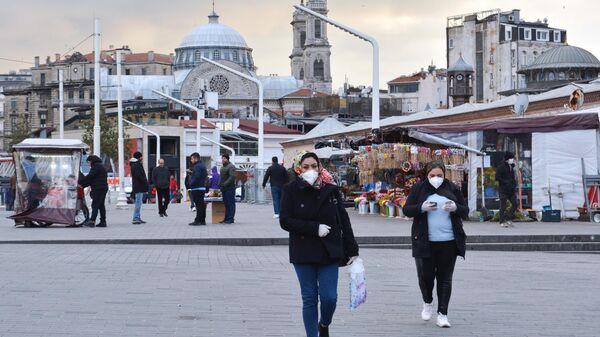 Прохожие в медицинских масках на одной из улиц в Стамбуле