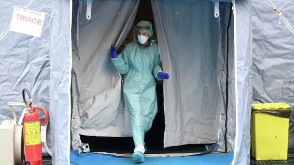 Медицинский работник у входа в больницу Spedali Civili в городе Брешиа, Италия