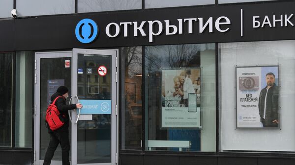 Посетитель заходит в отделение банка Открытие на одной из улиц в Москве