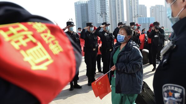 Полицейские приветствуют медицинского работника, покидающего эпицентр вспышки коронавирусной болезни (COVID-19) в провинции Хубэй, Китай