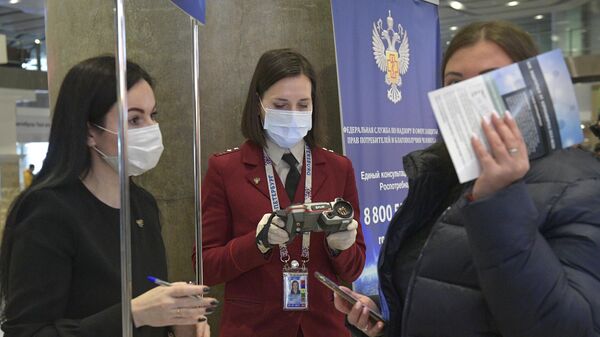 Сотрудник Роспотребнадзора с прибором для измерения температуры прибывающих в аэропорт Пулково