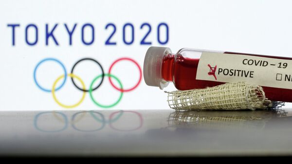 Fake blood in seen in test tubes labelled with coronavirus disease (COVID-19) in front of a displayed Tokyo 2020 Olympics logo in this illustration taken March 19, 2020. REUTERS/Dado Ruvic/Illustration