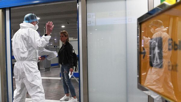 Сотрудник Роспотребнадзора встречает российских туристов, прилетевших из Черногории в аэропорту Шереметьево