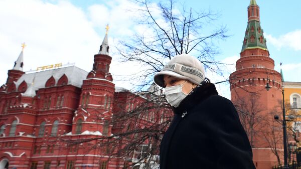 Женщина в защитной маске у стен Кремля в Москве