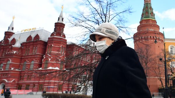 Женщина в защитной маске у стен Кремля в Москве