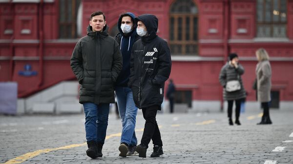 Прохожие в защитных масках на Красной площади в Москве