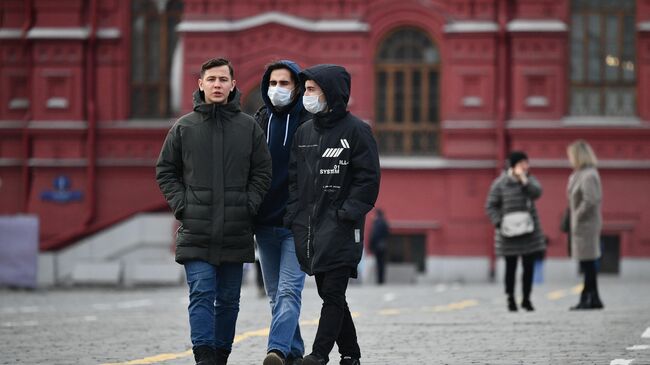 Прохожие в защитных масках на Красной площади в Москве