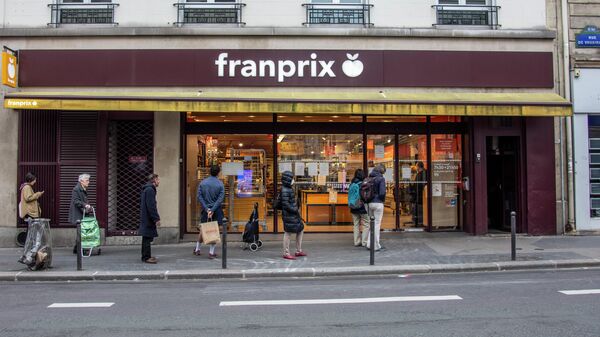 Люди стоят в очереди возле продуктового магазина в Париже