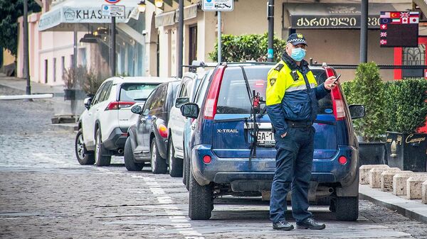 Полицейский в защитной маске на улице Тбилиси