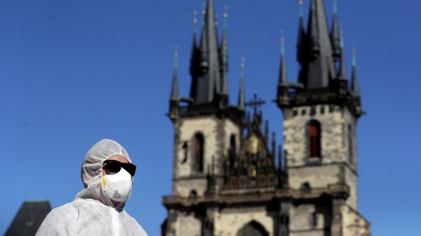 Мужчина в защитном костюме на Староместской площади в Праге
