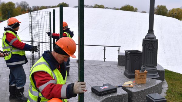 Рабочие устанавливают ограждение вокруг фонтана после демонтажа в парке Царицыно в Москве