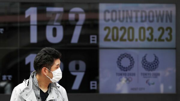 A passersby, wearing a face mask due to the outbreak of the coronavirus disease (COVID-19), walks past a screen counting down the days to the Tokyo 2020 Olympic Games in Tokyo, Japan March 23, 2020. REUTERS/Issei Kato     TPX IMAGES OF THE DAY