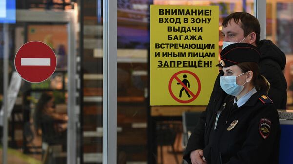 Сотрудница полиции в медицинской маске в аэропорту Толмачево