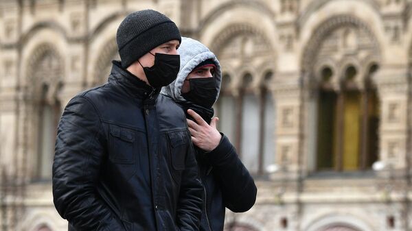 Прохожие в защитных масках на Красной площади в Москве.