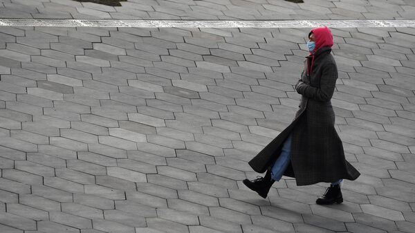 Женщина в медицинской маске на одной из улиц Москвы