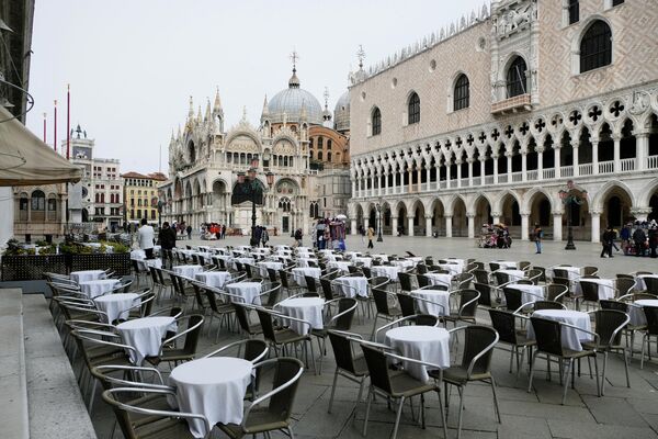 Пустые столики перед рестораном на площади Сан - Марко в Венеции