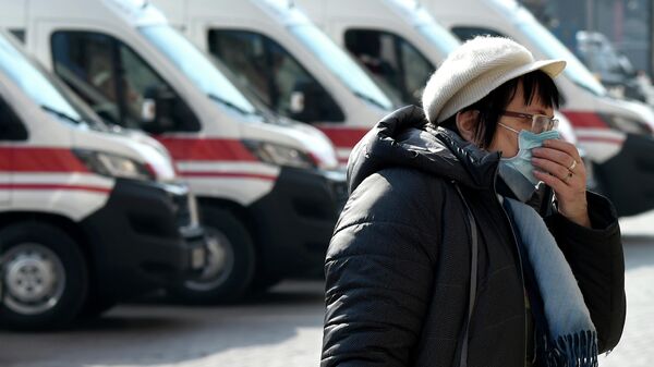 Женщина на фоне автомобилей скорой помощи в Киеве