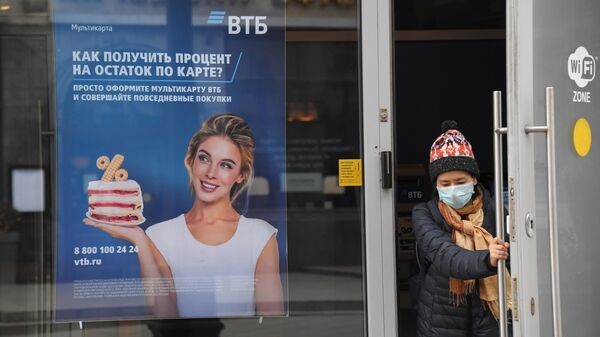 Посетитель выходит из отделения банка ВТБ на одной из улиц в Москве