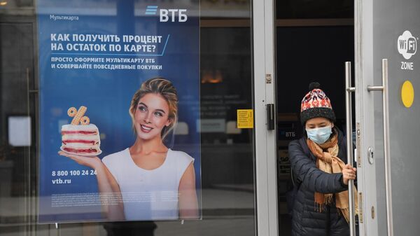 Посетитель выходит из отделения банка ВТБ на одной из улиц в Москве