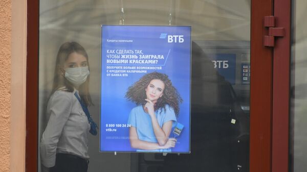 Сотрудница в защитной маске в отделении банка ВТБ на одной из улиц в Москве