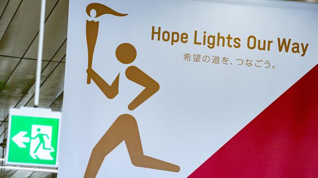 A poster for the Tokyo 2020 torch relay (R) is pictured inside Fukushima railway station in Fukushima Prefecture on March 24, 2020. - The Olympic torch relay, due to begin on March 25 from a symbolic site in Fukushima, will proceed as scheduled but organisers said they would re-assess in the coming days given the worsening COVID-19 coronavirus situation. (Photo by Philip FONG / AFP)