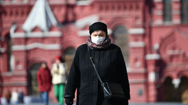 Женщина в защитной маске на Красной площади в Москве