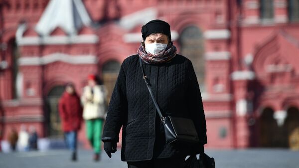 Женщина в защитной маске на Красной площади в Москве