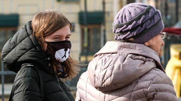 Прохожие в защитных масках на Невском проспекте в Санкт-Петербурге