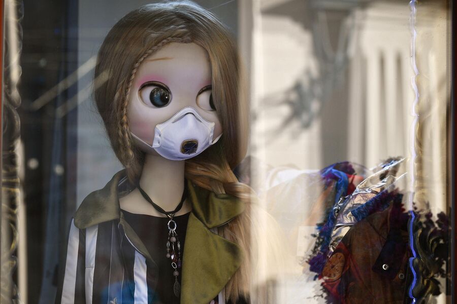 Кукла в защитной маске в витрине магазина