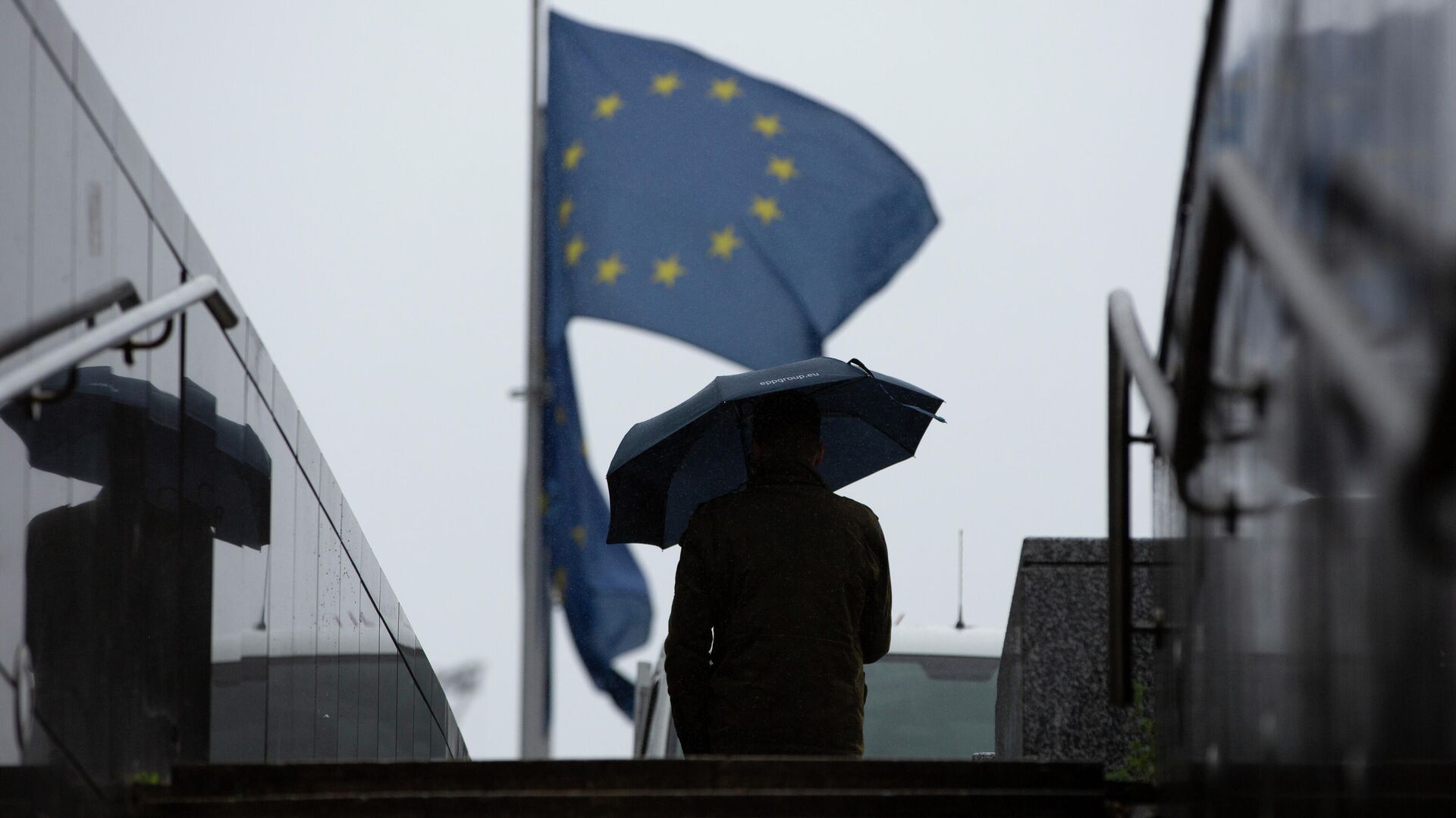 Мужчина проходит мимо штаб-квартиры ЕС в Брюсселе - РИА Новости, 1920, 23.07.2020