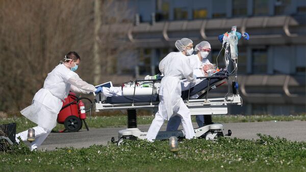 Медицинские работники везут пациента с коронавирусной инфекцией в городе Мюлуз, Франция