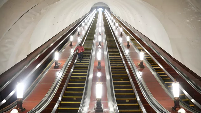 Человек на эскалаторе Московского метрополитена Человек на эскалаторе Московского метрополитена