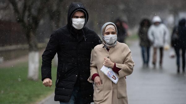 Люди в медицинских масках идут по улице Симферополя