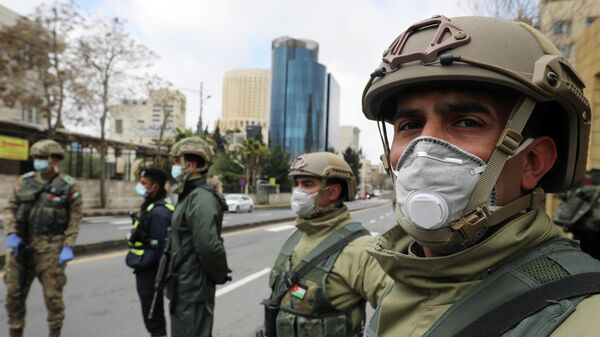 Иорданские военные в защитных масках на контрольно-пропускном пункте в Аммане