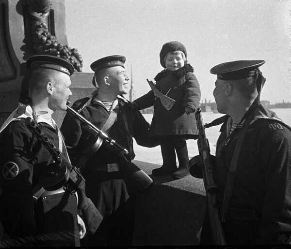 Моряки Балтийского флота беседуют с девочкой Люсей. Её и других детей вывозят из блокадного города