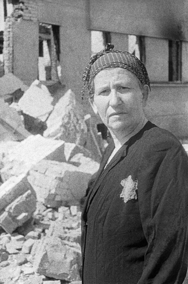 Жительница еврейского гетто на развалинах родного дома